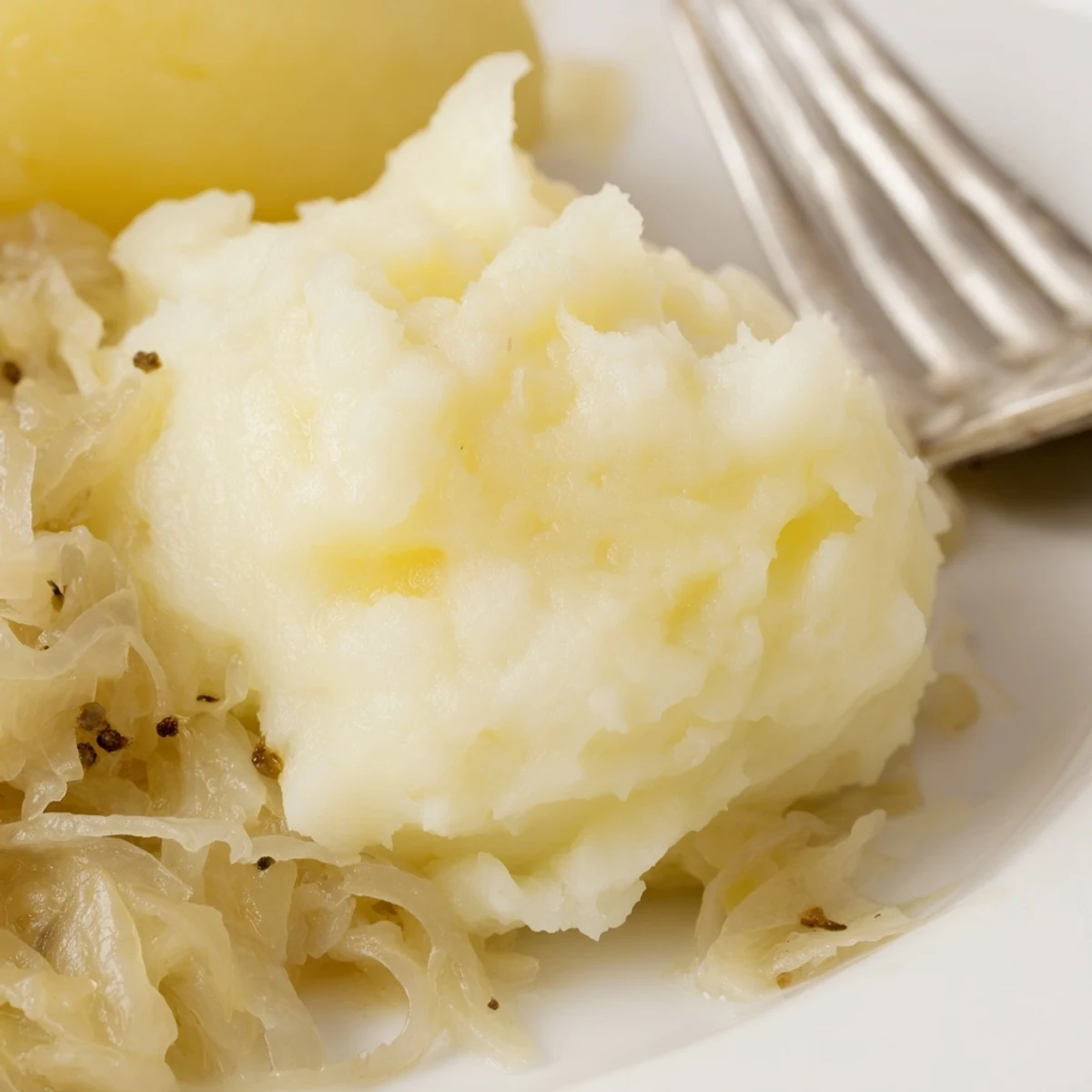 Cremige Kartoffelpüree-Mischung, perfekt kombiniert mit würzigem Sauerkraut-Stir-Fry.  